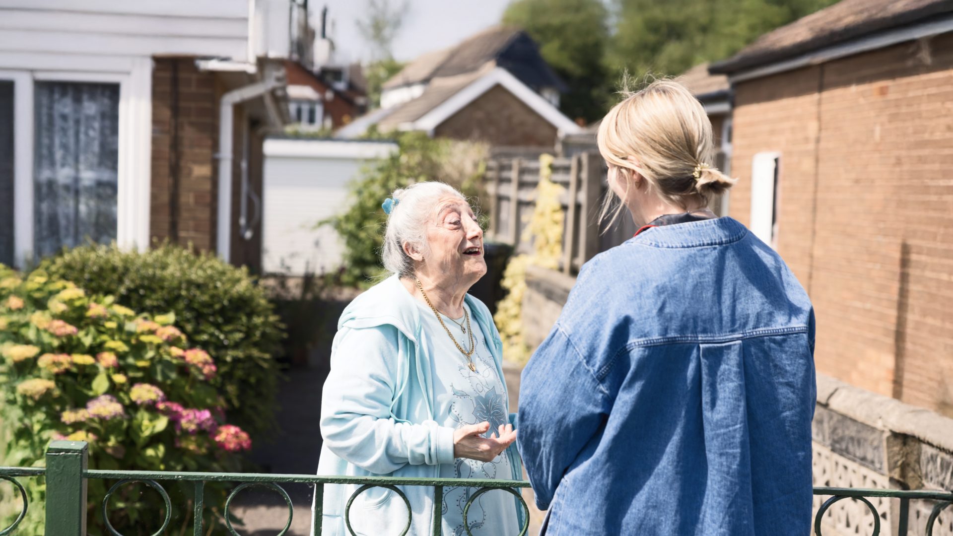 Older lady chatting to younger lady outside home