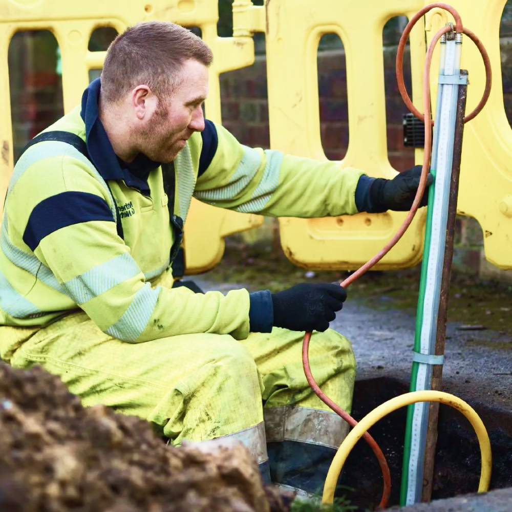 Northern Gas worker on building site looking at pipe
