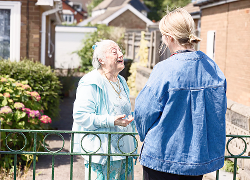 Older lady chatting to younger lady outside home