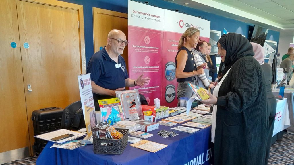 Image of male representative from National Energy Action sharing advice with woman wearing a black hijab.