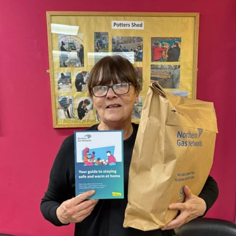 Women in Centre for Warmth holding an NGN winter warmer pack.
