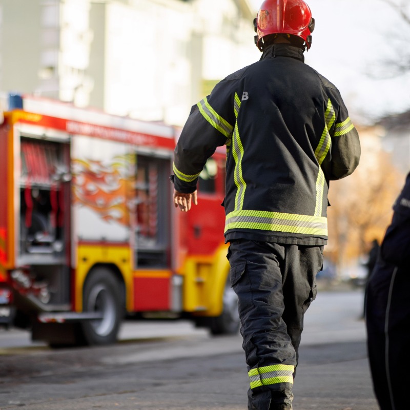 Image of back of fire service crew member walking towards fire engine.