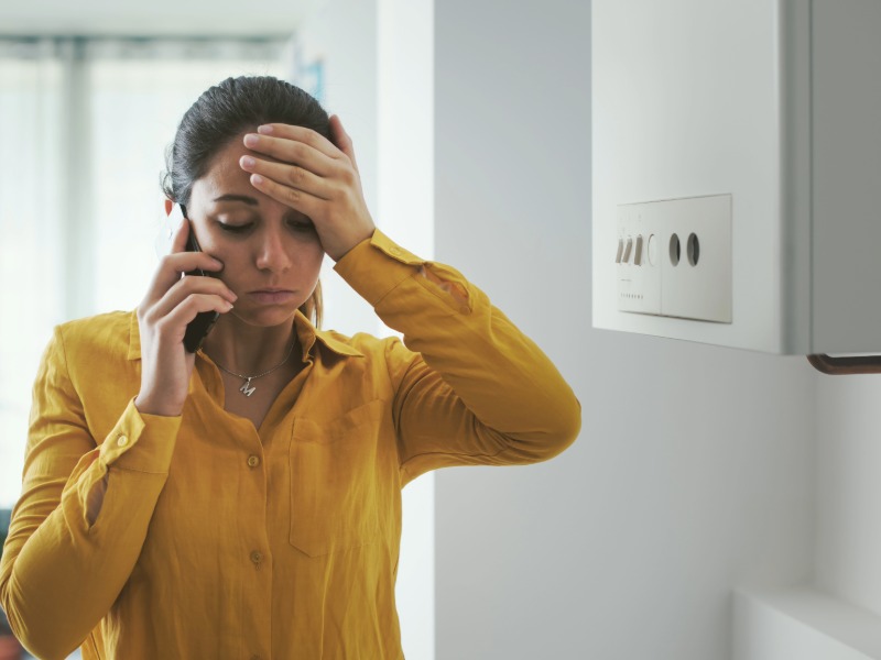 Image of young woman worried as her boiler is broken.